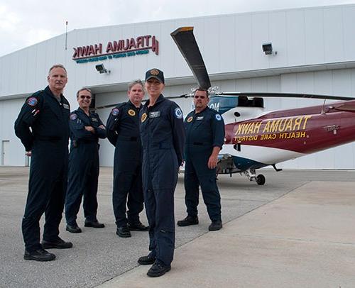 “创伤之鹰”的机组人员站在“创伤之鹰”前的航空医疗中心